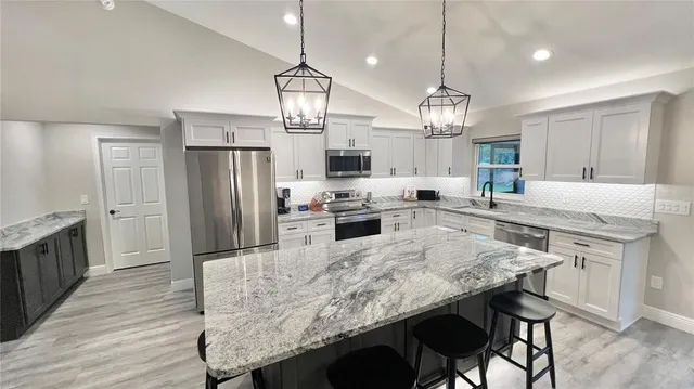 a kitchen with granite countertop center island and stainless steel appliances
