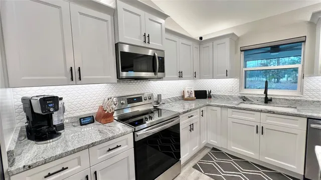 a kitchen with appliances a sink and cabinets