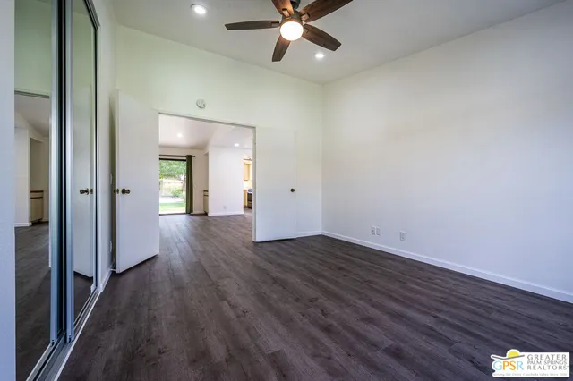 a view of a hallway with wooden floor and closet area