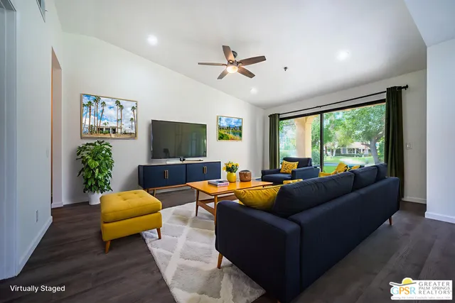 an empty room with wooden floor and a kitchen