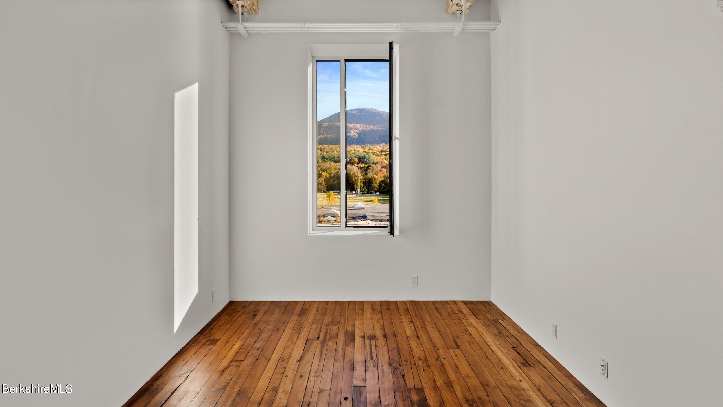 520 State Road, Unit 305 North Adams, MA 01247 - Photo 10 of 27 a view of an empty room with wooden floor and a window