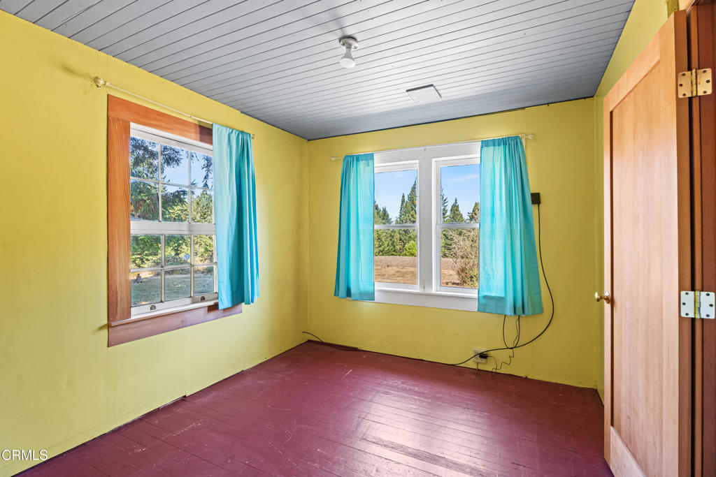 28580 Comptche Ukiah Road Comptche, CA 95427 - Photo 17 of 56 an empty room with wooden floor and windows