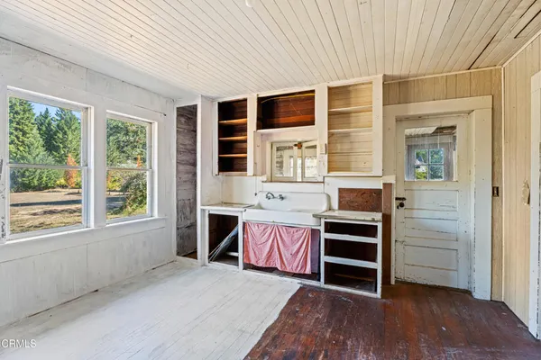 a view of a wooden door with a bench in a patio
