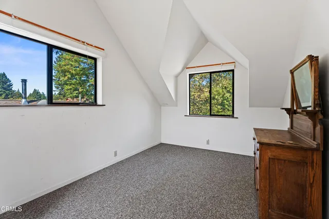 a view of a house with a small yard plants and large tree