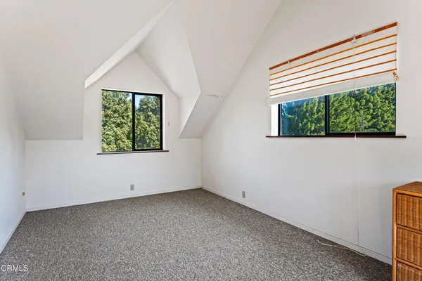 an empty room with a fireplace and windows