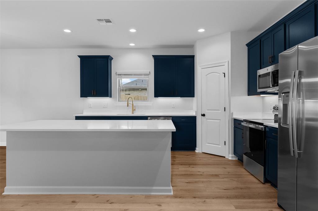 1269 BAYOU BAY Court Frierson, LA 71027 - Photo 12 of 30 a large kitchen with stainless steel appliances a large counter top a stove and a refrigerator