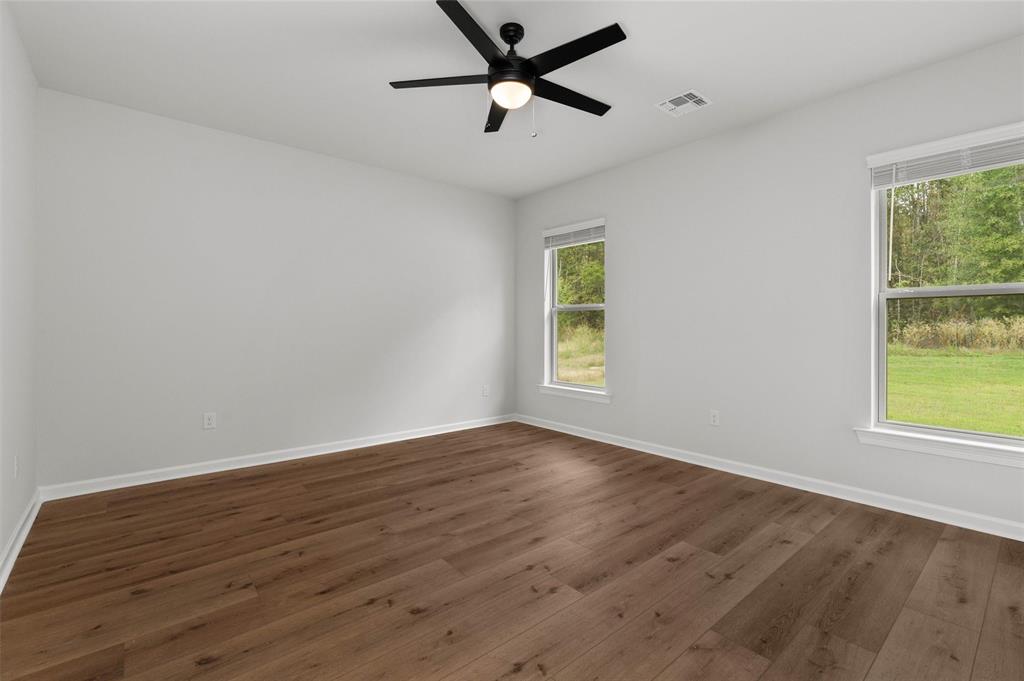 1269 BAYOU BAY Court Frierson, LA 71027 - Photo 17 of 30 an empty room with wooden floor ceiling fan and windows