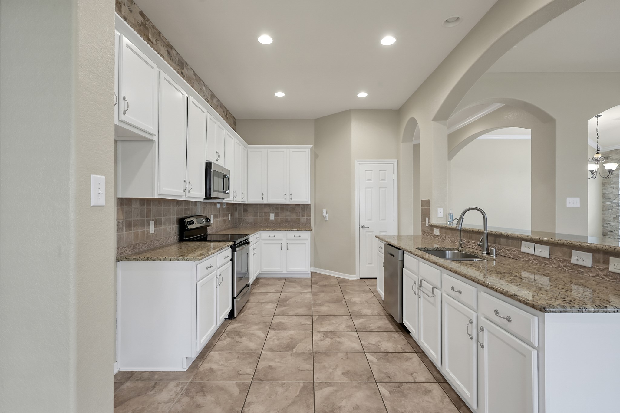 12419 Adams Ridge Lane Humble, TX 77346 - Photo 14 of 46 a large kitchen with stainless steel appliances granite countertop a sink and cabinets