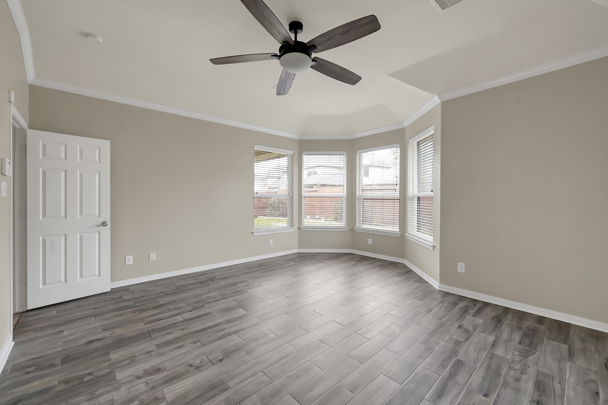 12419 Adams Ridge Lane Humble, TX 77346 - Photo 20 of 46 an empty room with wooden floor fan and windows