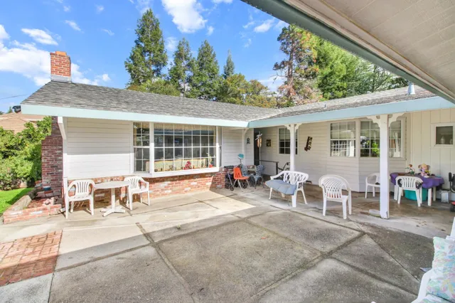 a patio with a table and chairs under an umbrella