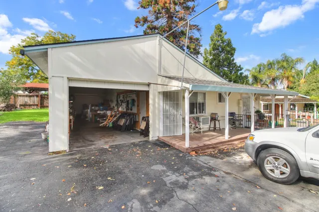 an aerial view of residential house with outdoor space and trees all around