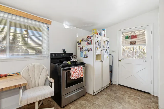 an aerial view of residential houses with outdoor space and trees