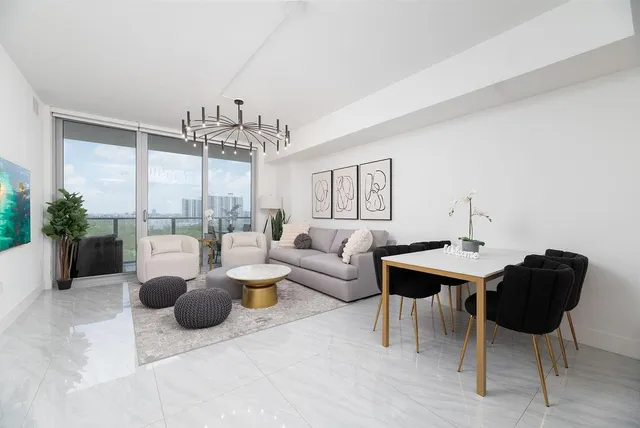 a living room with furniture a chandelier and a large window