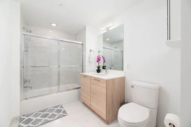 a bathroom with a sink a toilet and shower