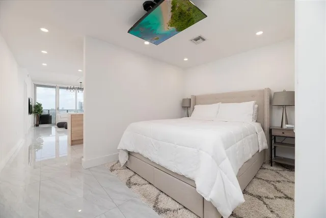 a spacious bedroom with a bed and a view of bathroom