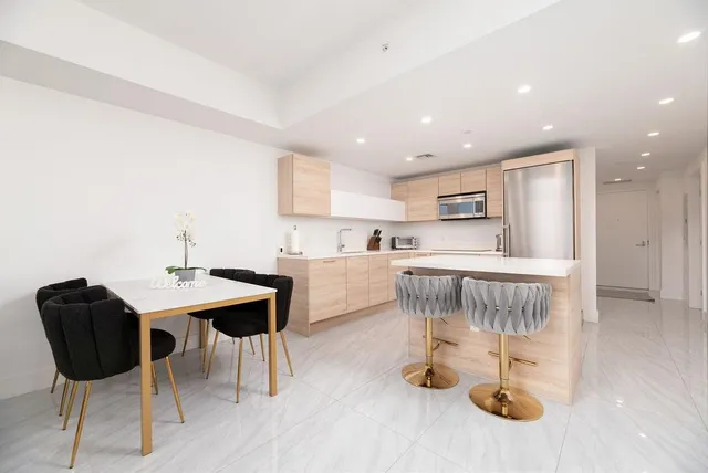 a kitchen with a dining table chairs and view living room