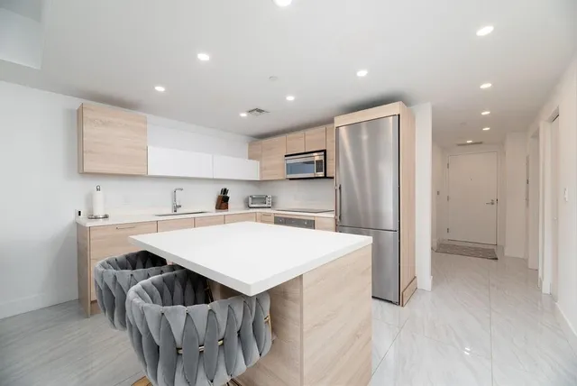 a kitchen with kitchen island a sink stove and refrigerator