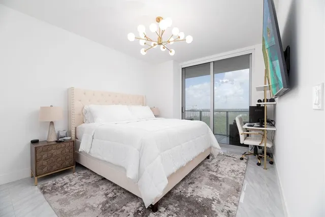 a bedroom with a bed and a chandelier