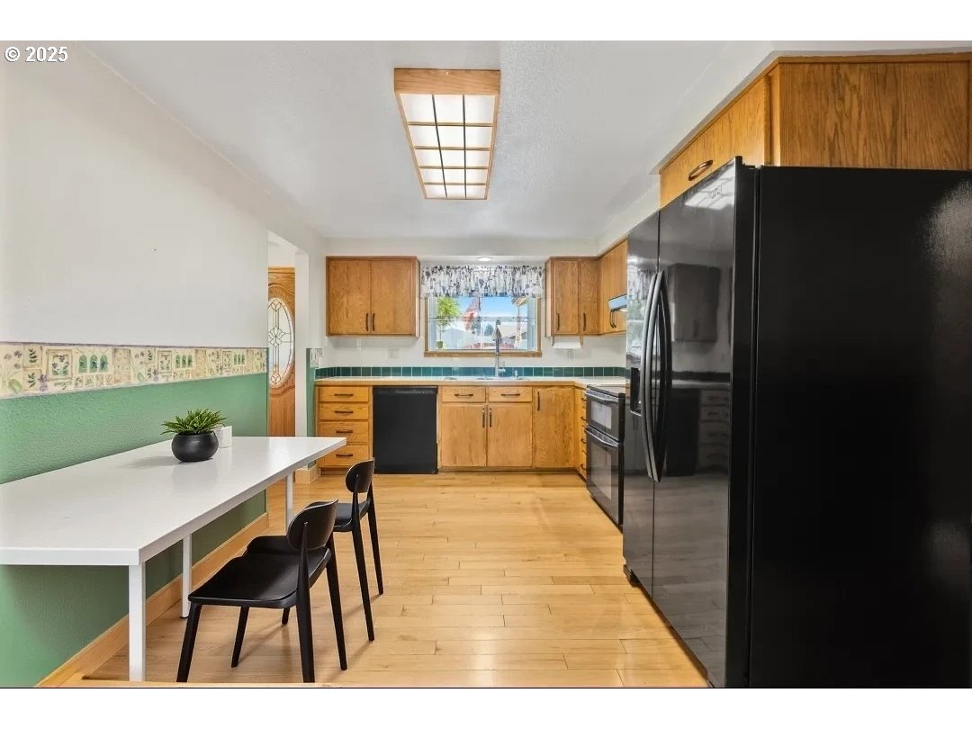 376 49th State Loop Springfield, OR 97478 - Photo 47 of 48 a kitchen with a table chairs refrigerator and cabinets