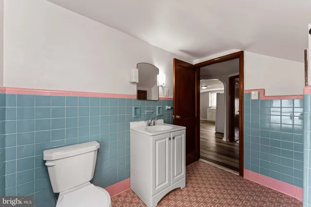 a bathroom with a toilet a sink and mirror