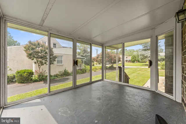 a view of an empty room with wooden floor and a floor to ceiling window