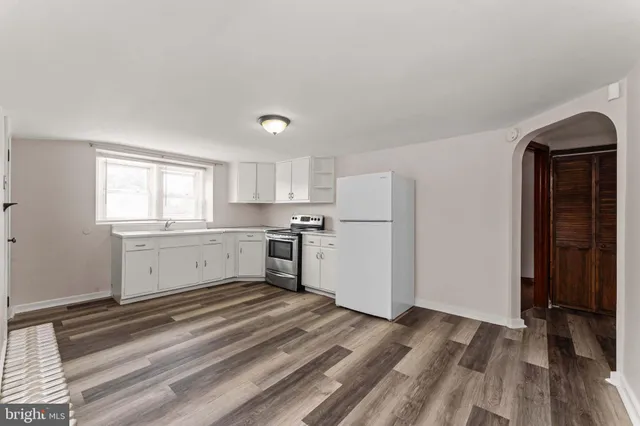 a view of a kitchen with wooden floor and electronic appliances