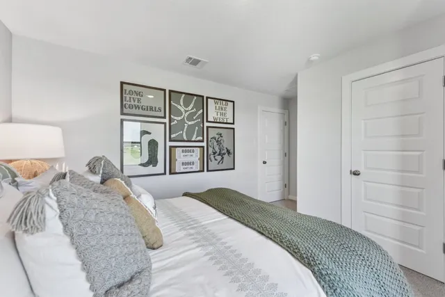a bedroom with a large bed and wooden floor