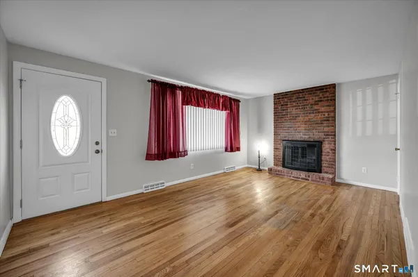 a view of a livingroom with wooden floor and a fireplace
