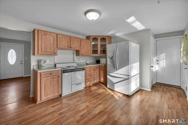 a kitchen with granite countertop a refrigerator and a stove top oven