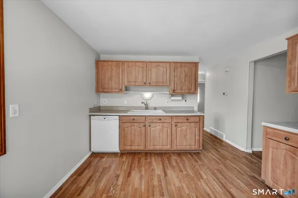 a kitchen with granite countertop a sink cabinets and wooden floor