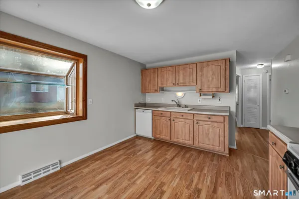 a kitchen with stainless steel appliances granite countertop a sink a stove cabinets and wooden floor