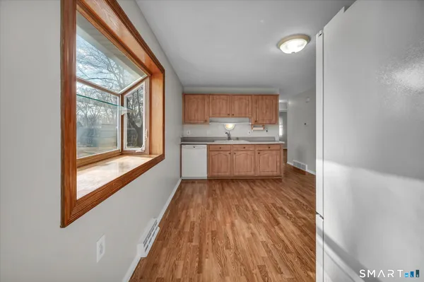a view of kitchen with wooden floor and electronic appliances