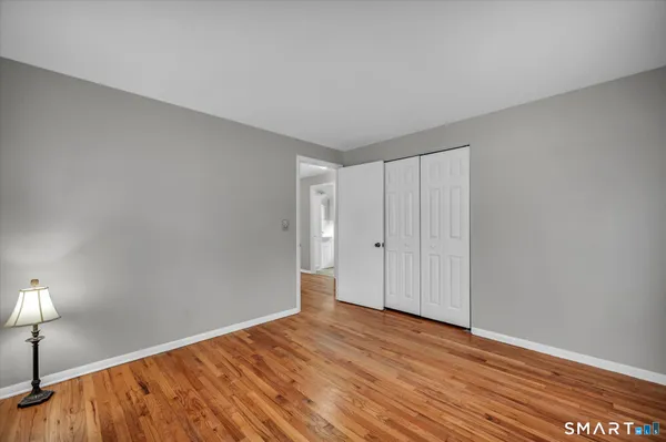 a view of empty room with wooden floor