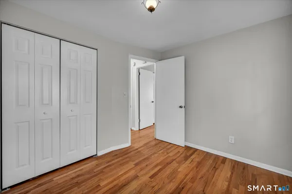 a view of an empty room with wooden floor