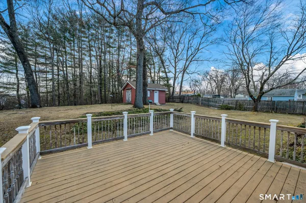 a view of house with deck and trees in the background