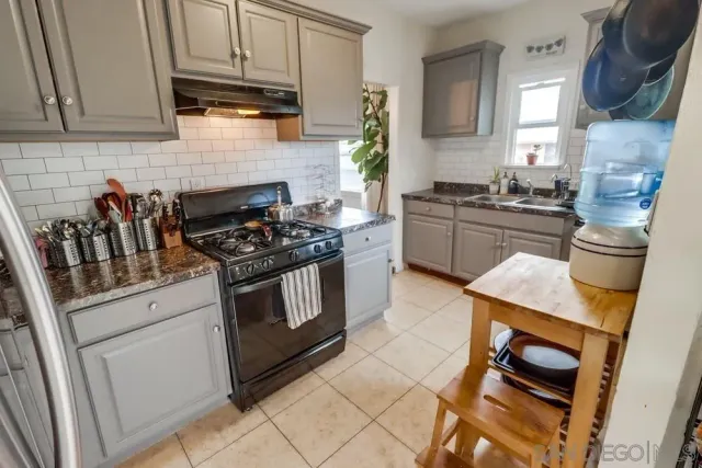a kitchen with granite countertop a stove and a sink