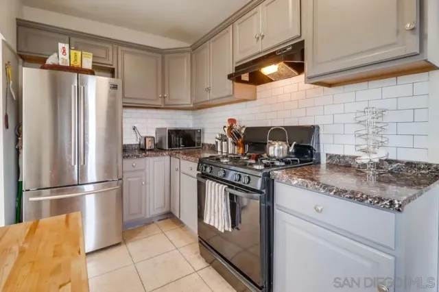 a kitchen with stainless steel appliances granite countertop a stove a refrigerator and a refrigerator