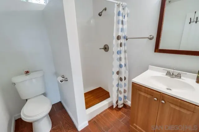 a bathroom with a sink a toilet and shower
