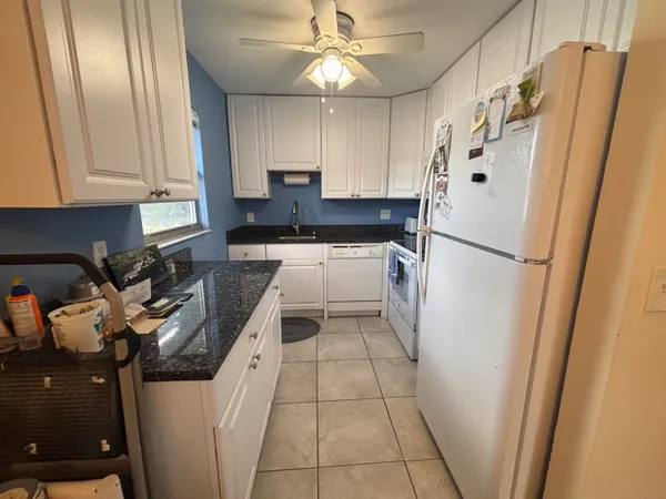 a kitchen with a refrigerator a stove top oven and cabinets