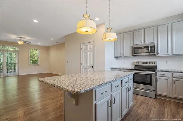 a kitchen with granite countertop a sink cabinets and stainless steel appliances