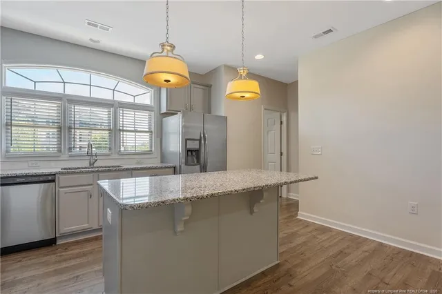a view of a kitchen with granite countertop a sink and a wooden floor