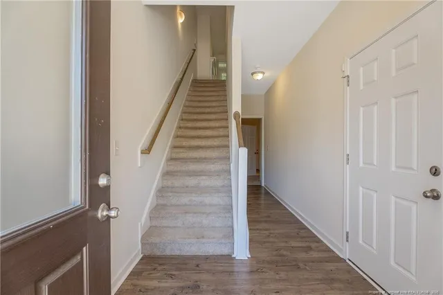 a view of staircase with wooden floor and white walls