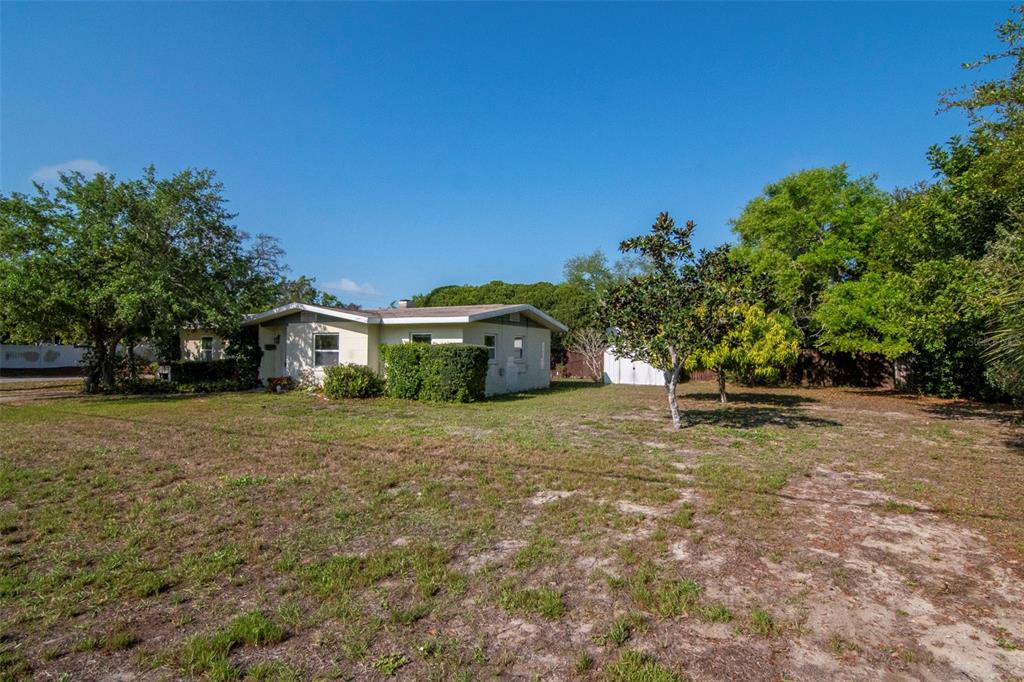 230 Milwaukee Avenue Dunedin, FL 34698 - Photo 50 of 61 a yellow house with trees in front of it