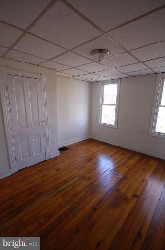 2218 Annapolis Road Baltimore, MD 21230 - Photo 11 of 15 an empty room with wooden floor and windows