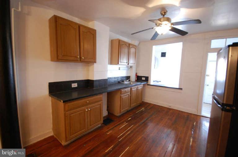 2218 Annapolis Road Baltimore, MD 21230 - Photo 4 of 15 a kitchen with stainless steel appliances granite countertop a sink a stove cabinets and wooden floor