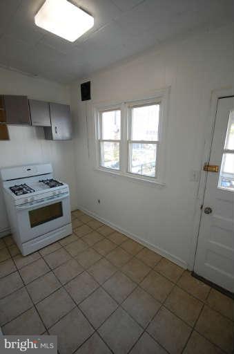 2218 Annapolis Road Baltimore, MD 21230 - Photo 6 of 15 a kitchen with granite countertop a stove a sink and a refrigerator