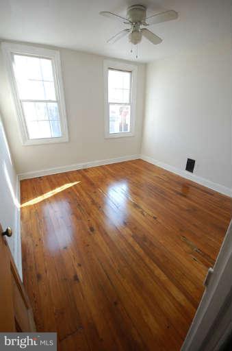 2218 Annapolis Road Baltimore, MD 21230 - Photo 8 of 15 an empty room with wooden floor and windows