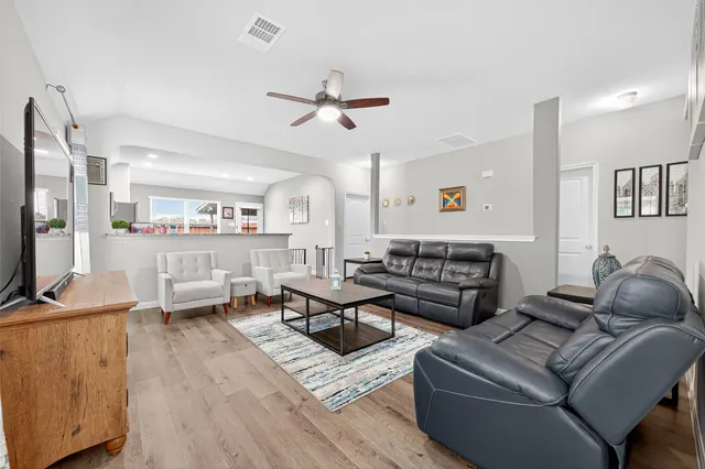 a living room with furniture wooden floor and a flat screen tv