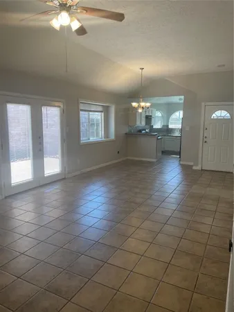 an empty room with kitchen and fireplace