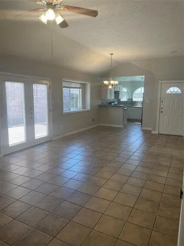 an empty room with wooden floor and chandelier fan